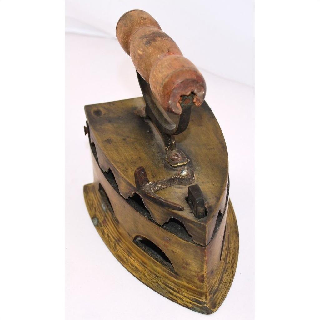 Brown wooden-handled antique Indonesian coal iron on white background, close-up view.