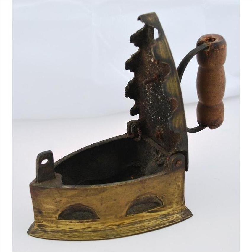 Brown wooden-handled metal coal iron with open lid and serrated edge on neutral surface.