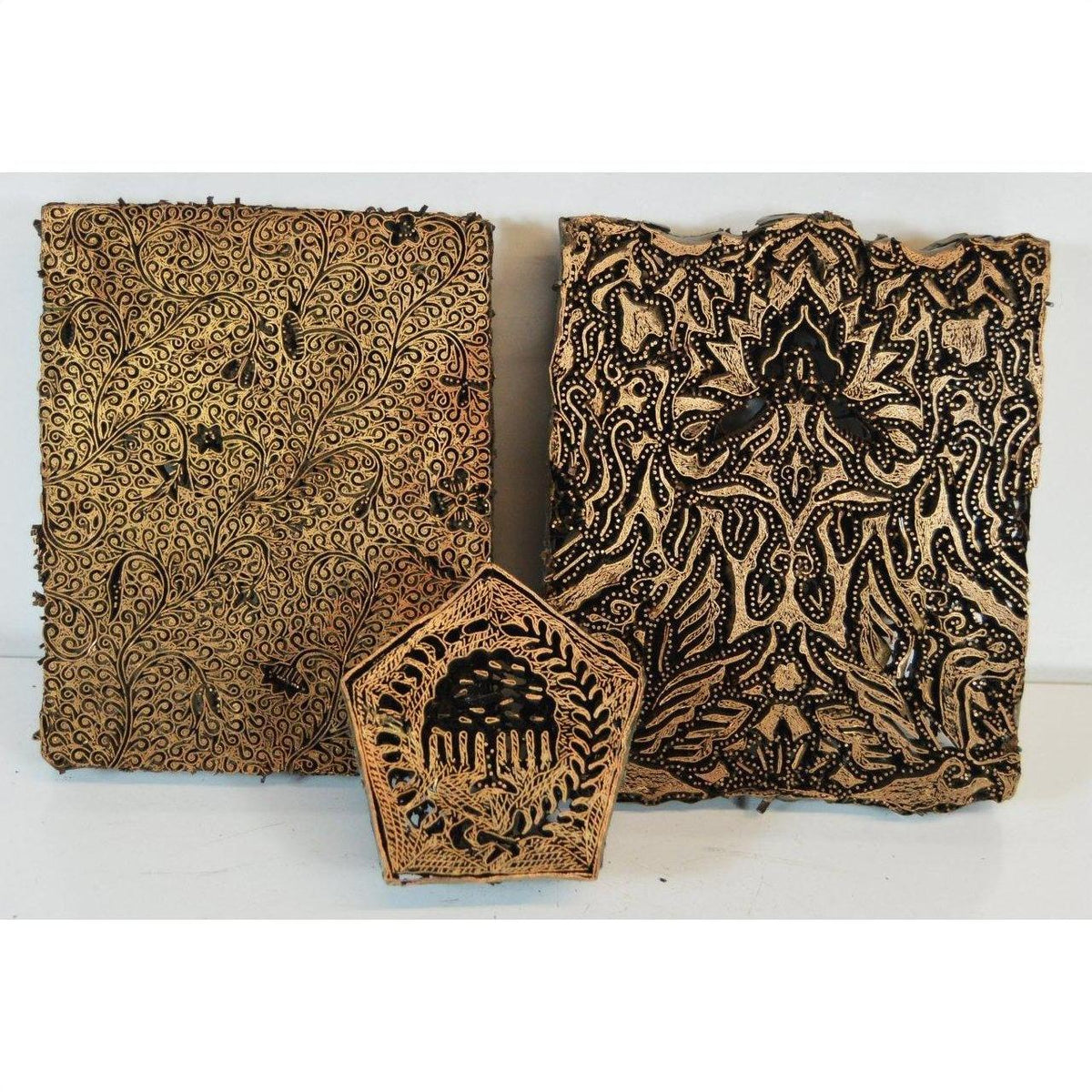 Copper Indonesian batik ink blocks with floral and geometric designs, set of 3 on white background.