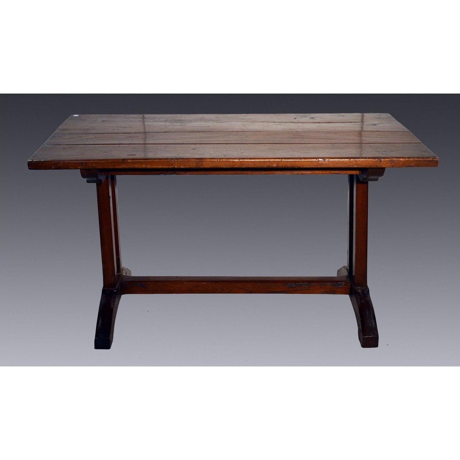 Rectangular teakwood antique Indonesian dining table with sturdy legs, set against a plain gray background.
