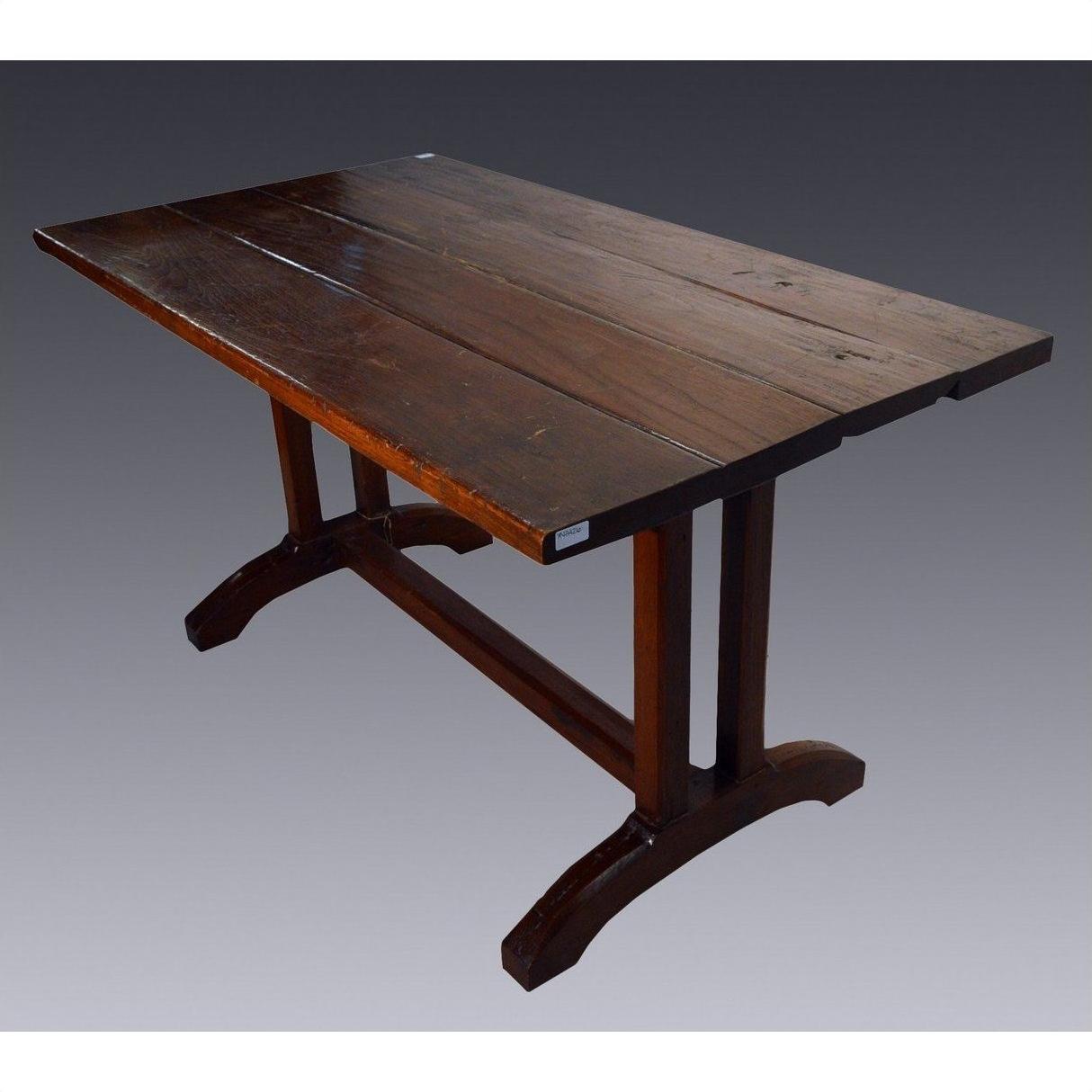 Dark teakwood plank dining table with sturdy trestle legs, placed against a gradient background.