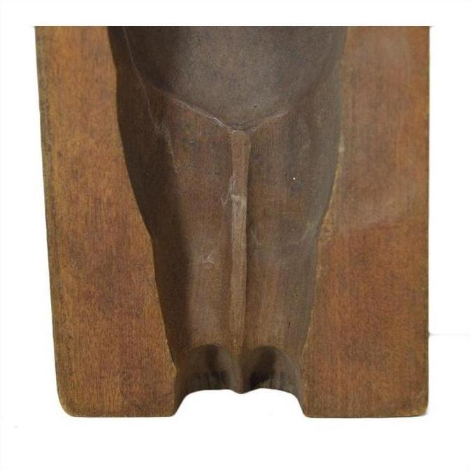 Close-up of brown wooden antique Indonesian hand-carved mold with smooth curved groove on rectangular base.