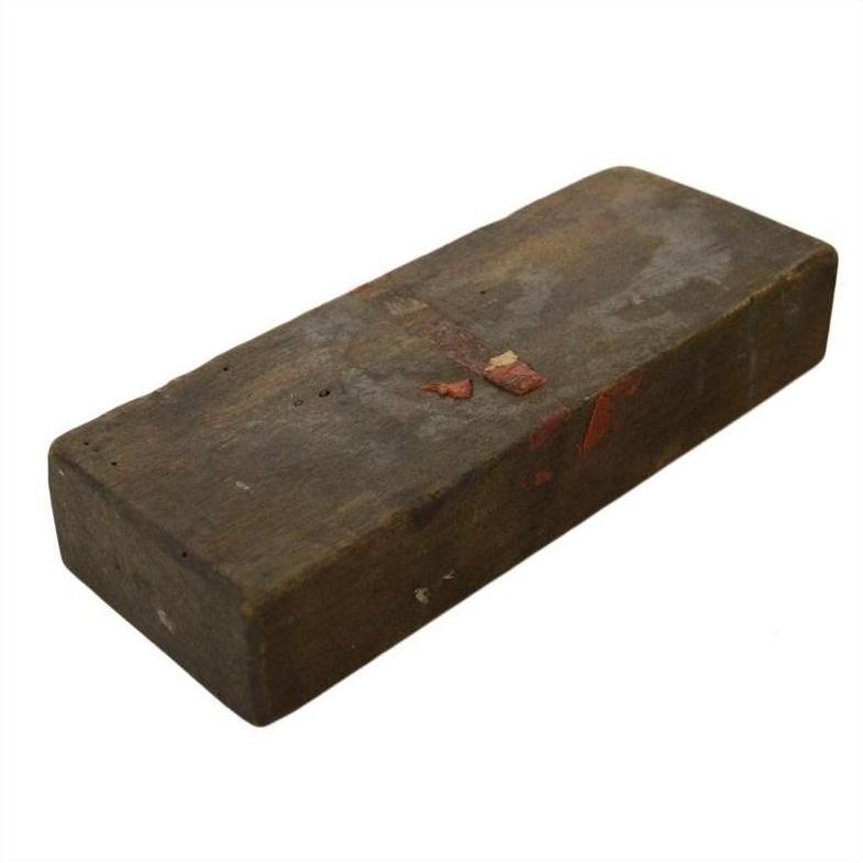 Brown brick with worn edges, made using antique Indonesian hand-carved wooden mold, close-up.