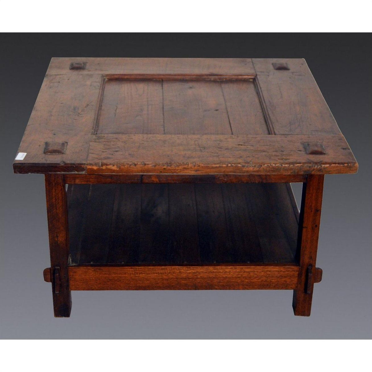 Brown wooden Indonesian table with lower shelf, visible joinery, Dutch Colonial inspired design, studio view.