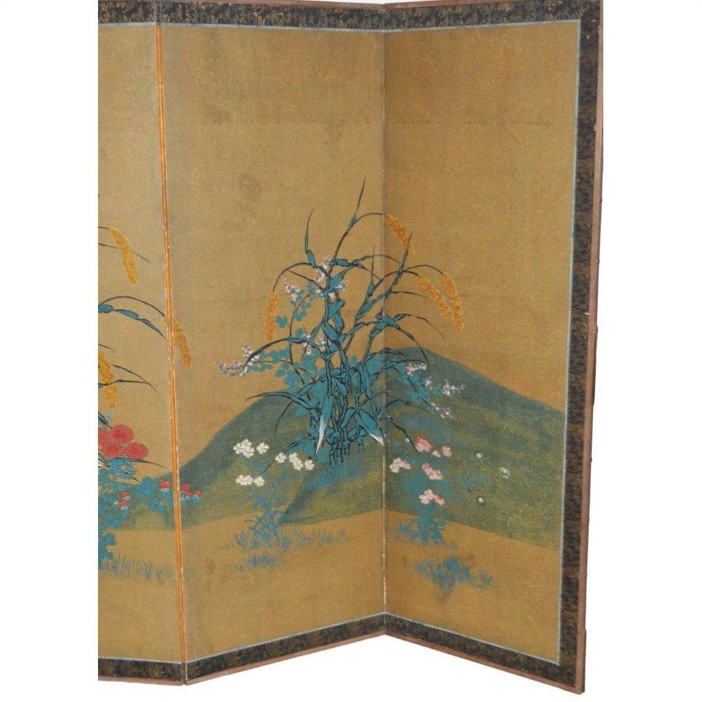 Gold gilt Japanese screen with painted green hill, grasses, and wildflowers on rice paper, dark blue border.