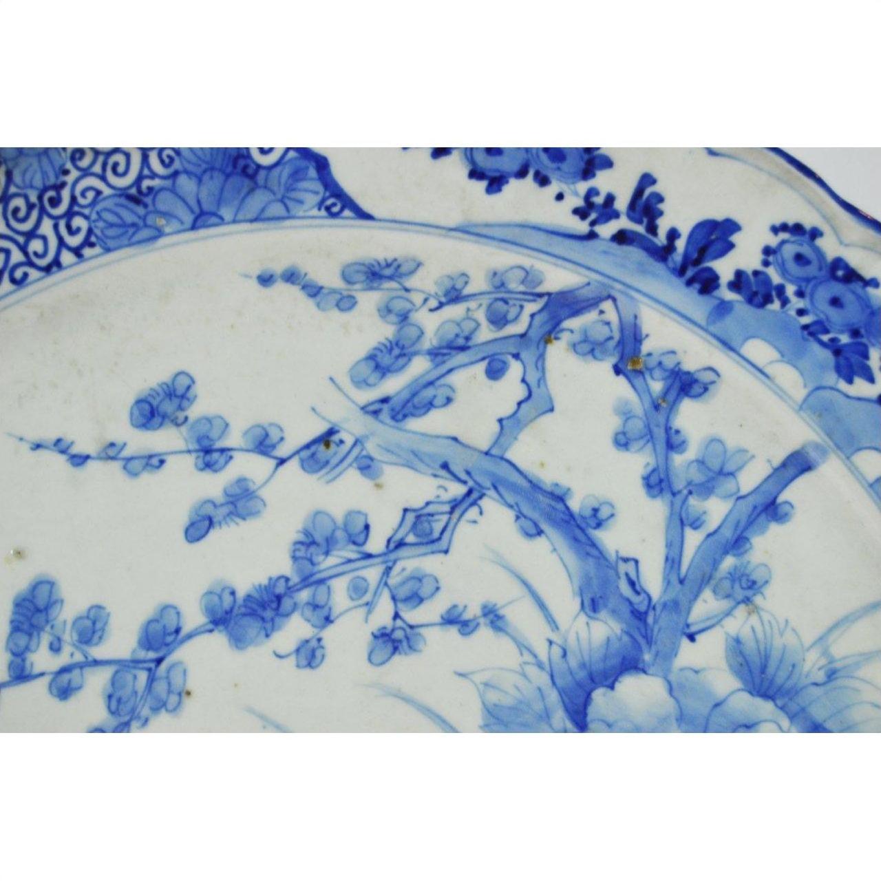 Close-up of white floral and branch patterns on ceramic Japanese hand painted plate.