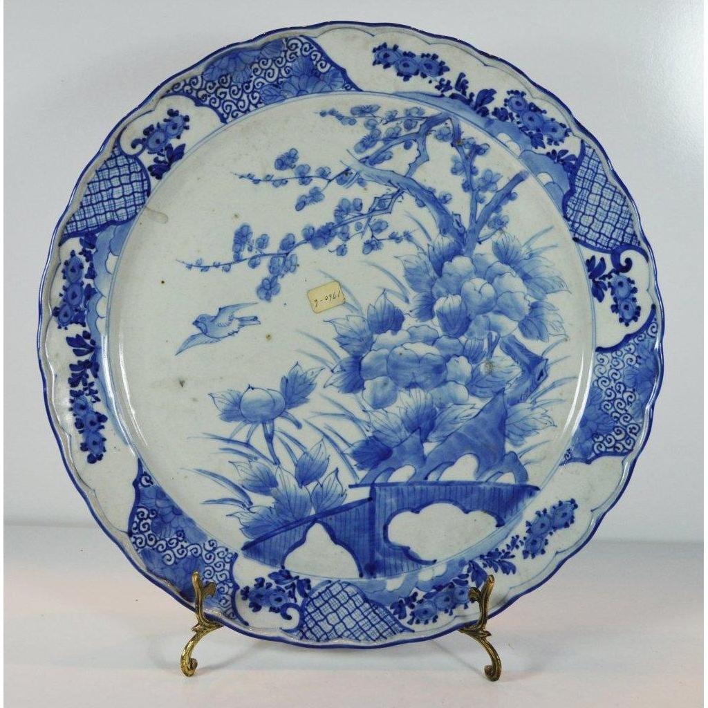 White ceramic Japanese hand painted plate with floral and bird design on a metal stand.