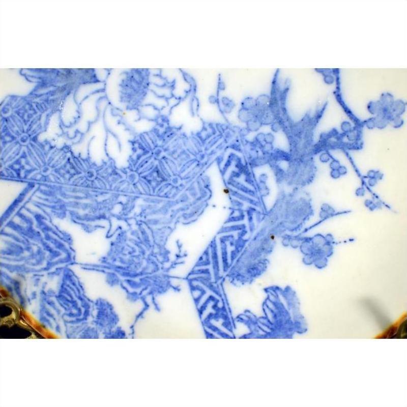 Blue porcelain Igezara transferware plate with floral and geometric patterns, delicate branch motifs, close-up.