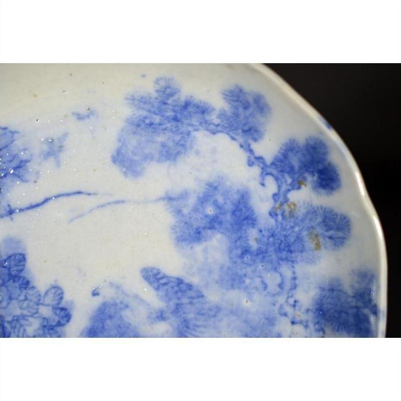 Close-up of blue porcelain Japanese Igezara transferware plate with floral and tree branch pattern, Meiji Period style.