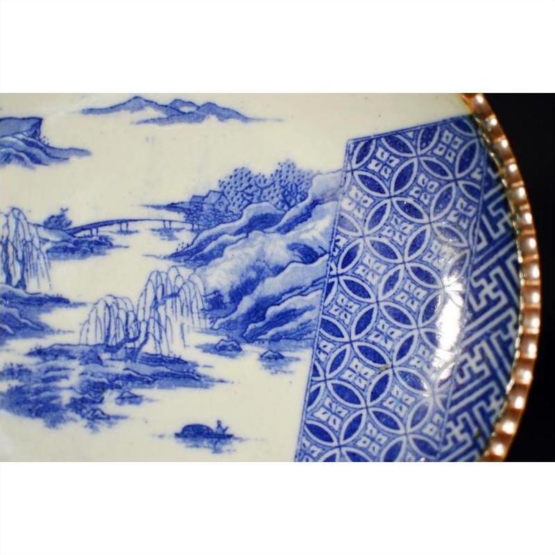 Blue and white ceramic Japanese Igezara plate with landscape, trees, river, and geometric rim design.
