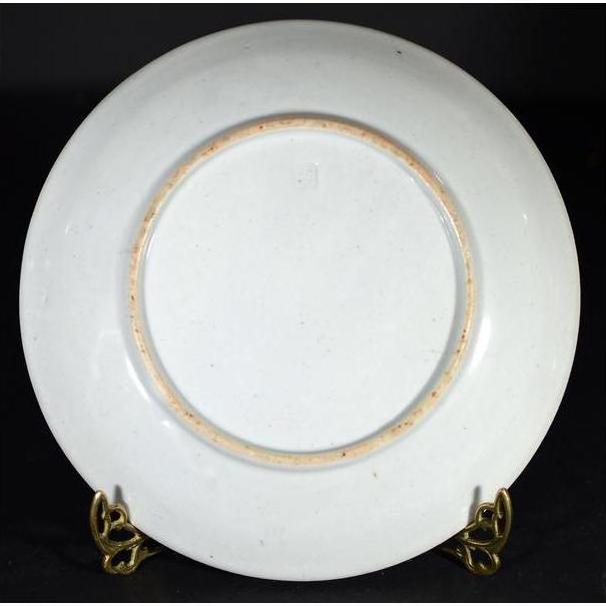 Blue and white porcelain Japanese Igezara transferware plate on a gold stand against a dark background.