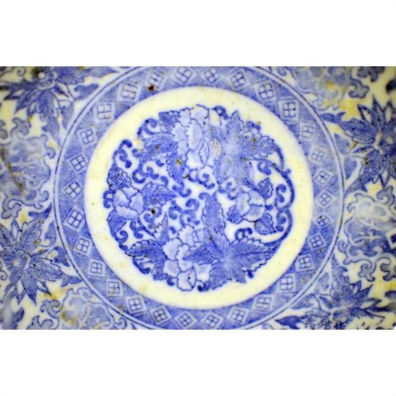 Blue and white ceramic Igezara transferware plate with circular floral and leaf pattern, close-up view.