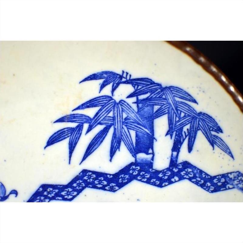 Blue and white porcelain Igezara plate with bamboo and geometric Asian motifs, transferware design, close-up.