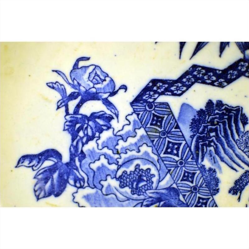 Close-up of blue and white porcelain Japanese Igezara plate with floral and geometric patterns.