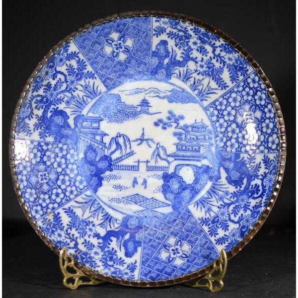 Blue and white porcelain Igezara plate with intricate floral patterns on a decorative stand.