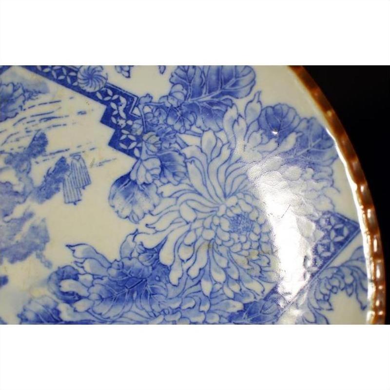 Close-up of blue and white porcelain Igezara Japanese plate with floral patterns and brown rim.
