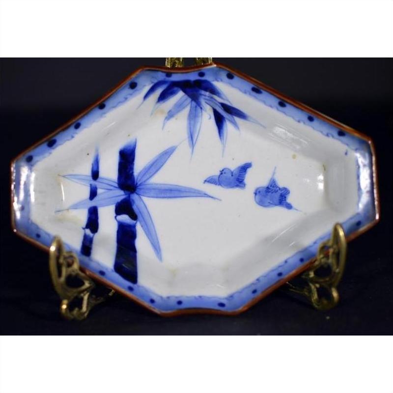 Blue and white porcelain Imari bowl with hand painted bamboo and birds, displayed on a metal stand.
