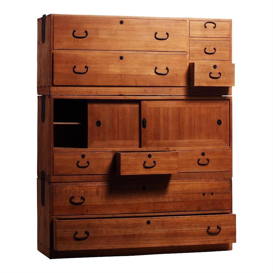 Brown Kiri wood Japanese chest with multiple drawers and sliding doors, some open, antique storage furniture.