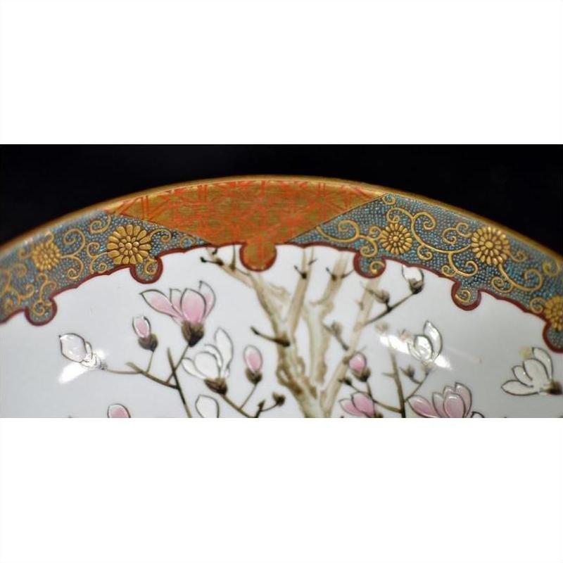 Close-up of an antique Japanese Kutani porcelain bowl with pink flowers and ornate gold, blue, and red hand-painted border.