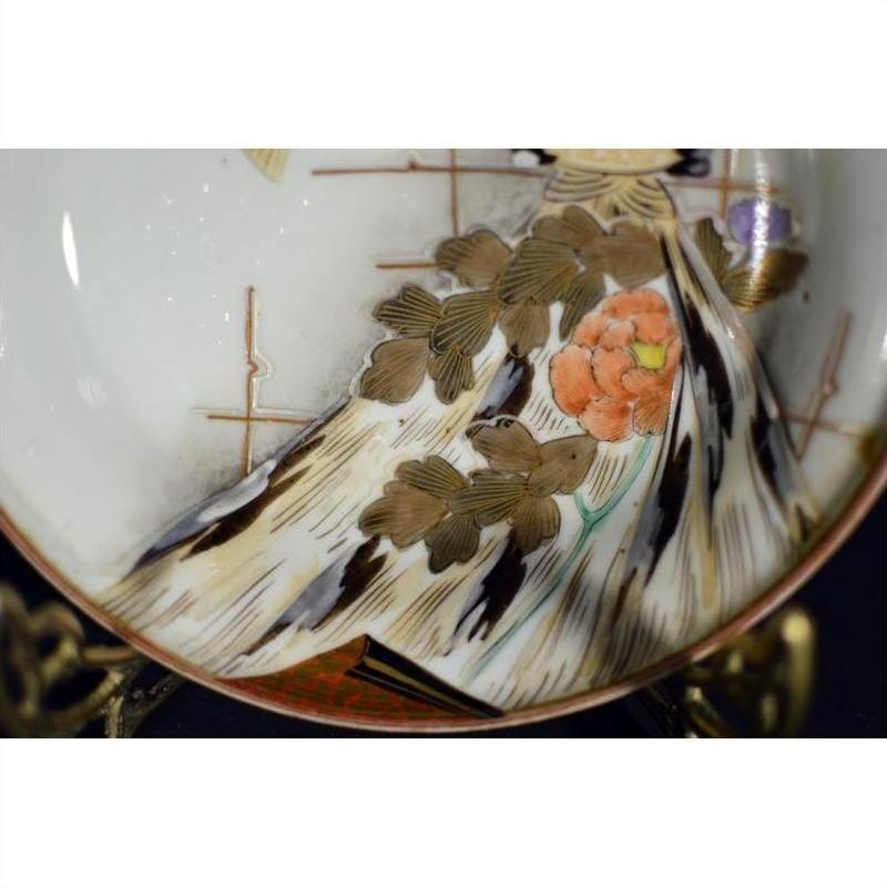 Close-up of an antique hand painted Japanese Kutani porcelain plate with orange flower and gold leaves.