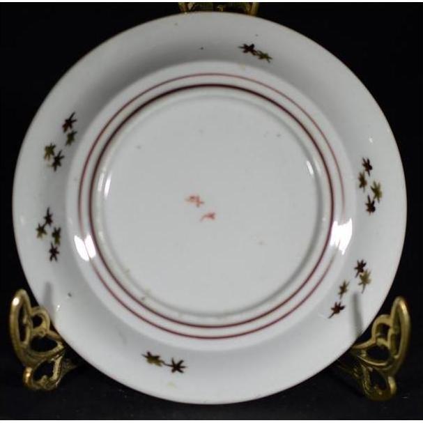 Antique hand painted Japanese Kutani porcelain plate on decorative metal stand.