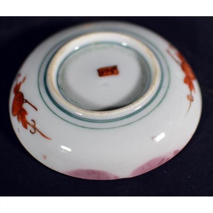 Close-up of a red floral hand painted Japanese Satsuma porcelain plate with brown label on base.
