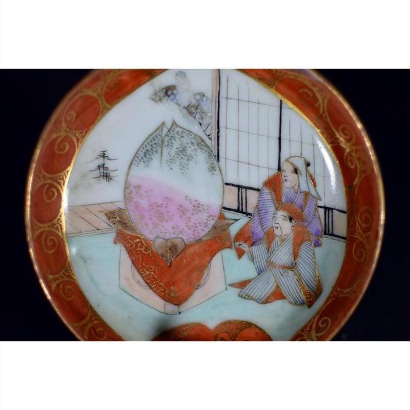 White ceramic Satsuma plate with two figures and a child beside a giant peach in a traditional Japanese scene.