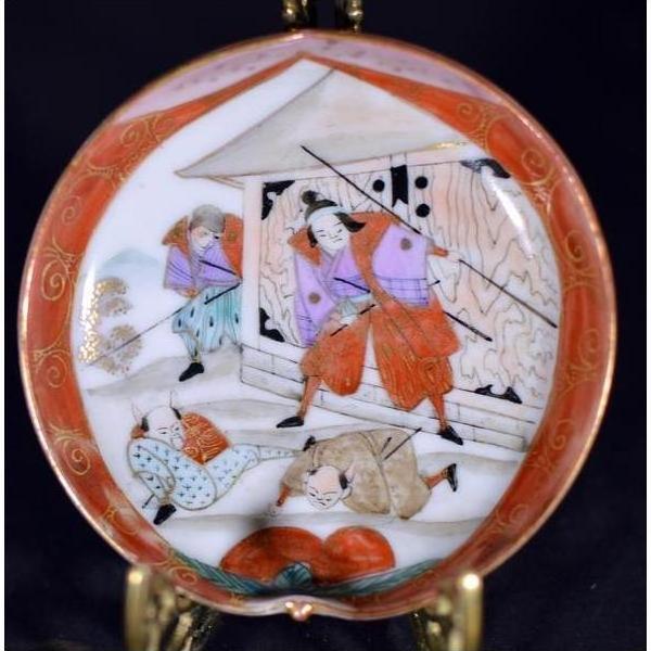 Colorful ceramic Satsuma plate with samurai in robes battling near a building with flying arrows, close-up view.