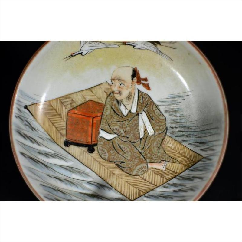 Antique Japanese Satsuma porcelain plate featuring a man in patterned robes with red box, hand painted design.