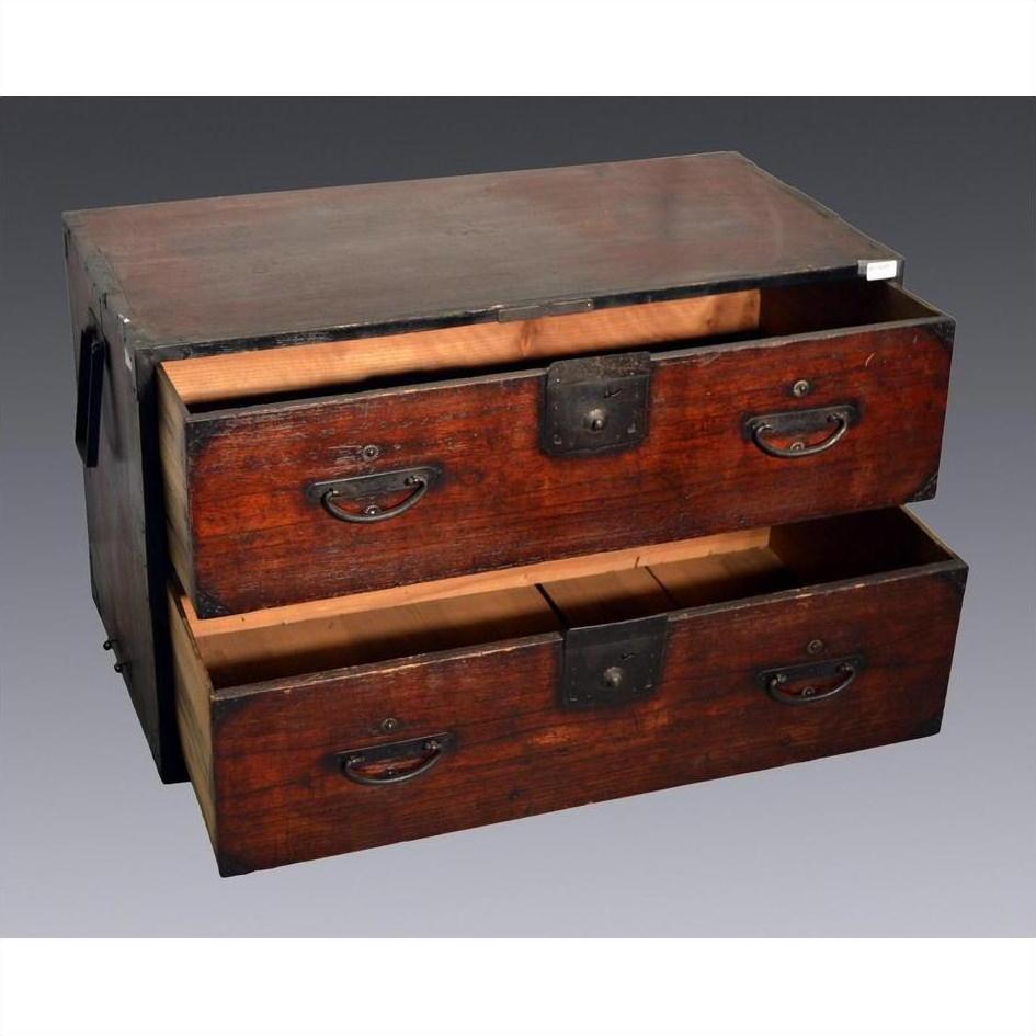 Brown wooden Japanese Tansu cabinet with metal handles and two open drawers, worn finish, close-up view.