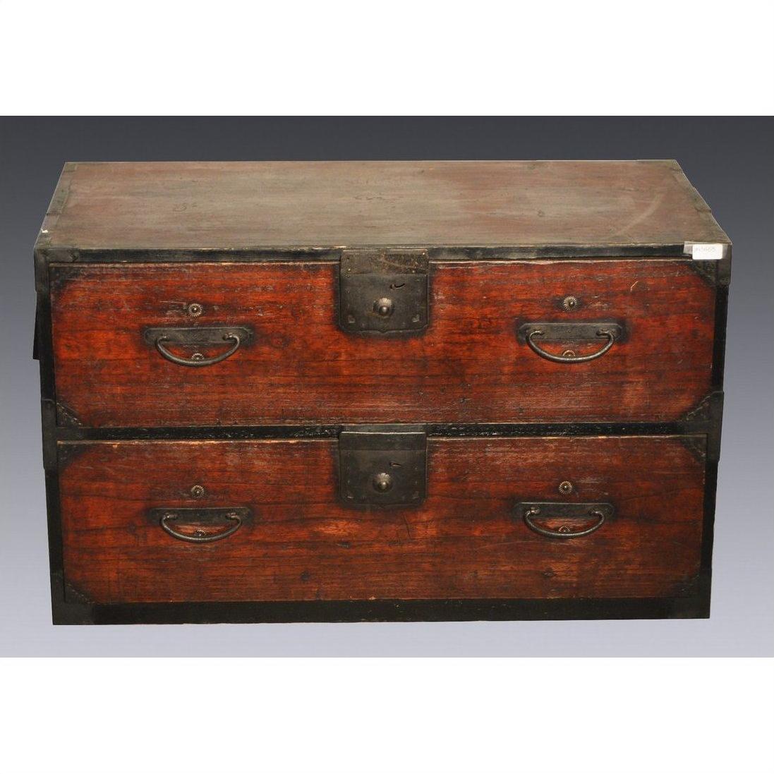 Dark wood Japanese Tansu with two large drawers, metal handles and corner brackets, shown on a gray background.