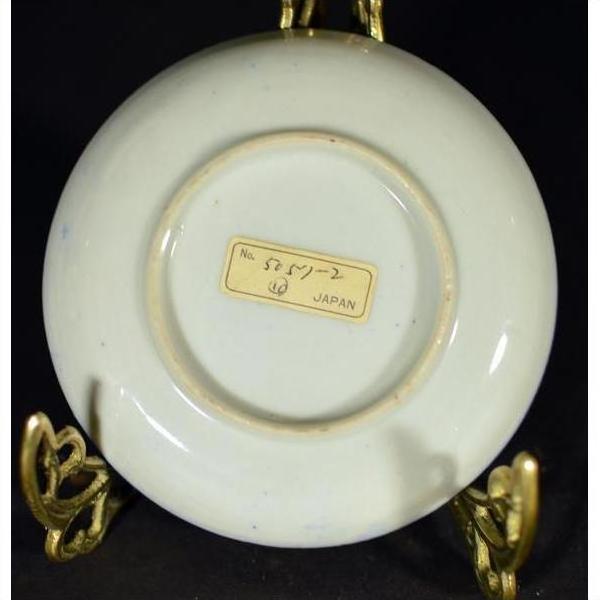 White porcelain Japanese transferware plate with "JAPAN" mark displayed on a decorative metal stand.
