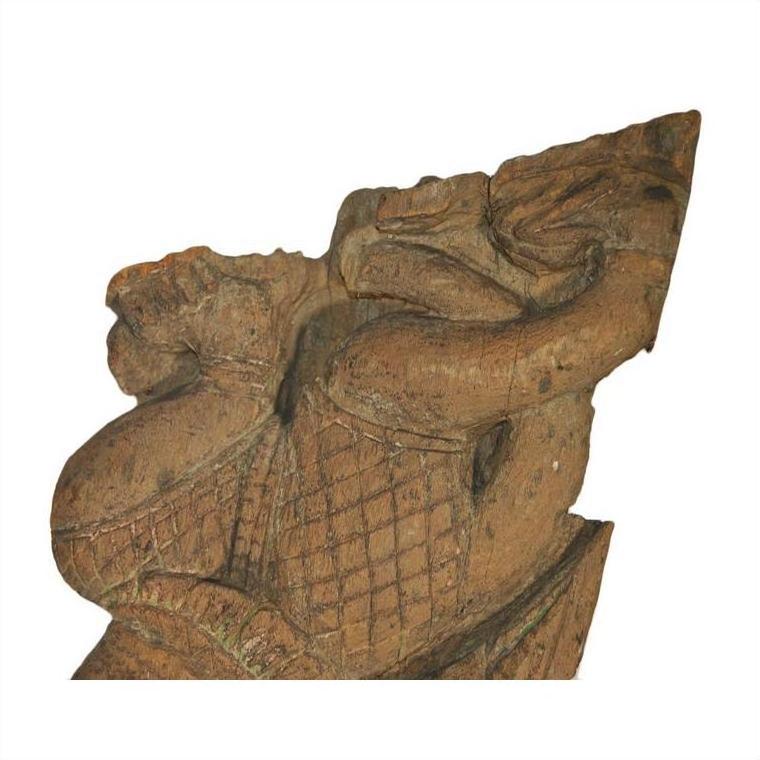 Brown wood Burmese temple carving, mirrored guardian relief with stylized headgear, isolated on white background.