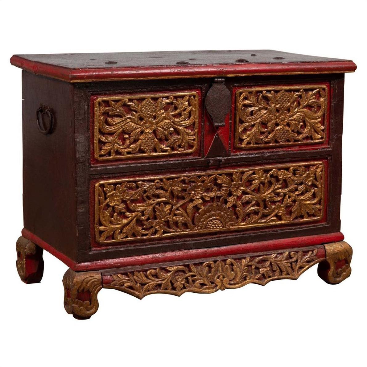 Brown hand carved wooden blanket chest with gilt accents, red details, two drawers, and decorative feet.