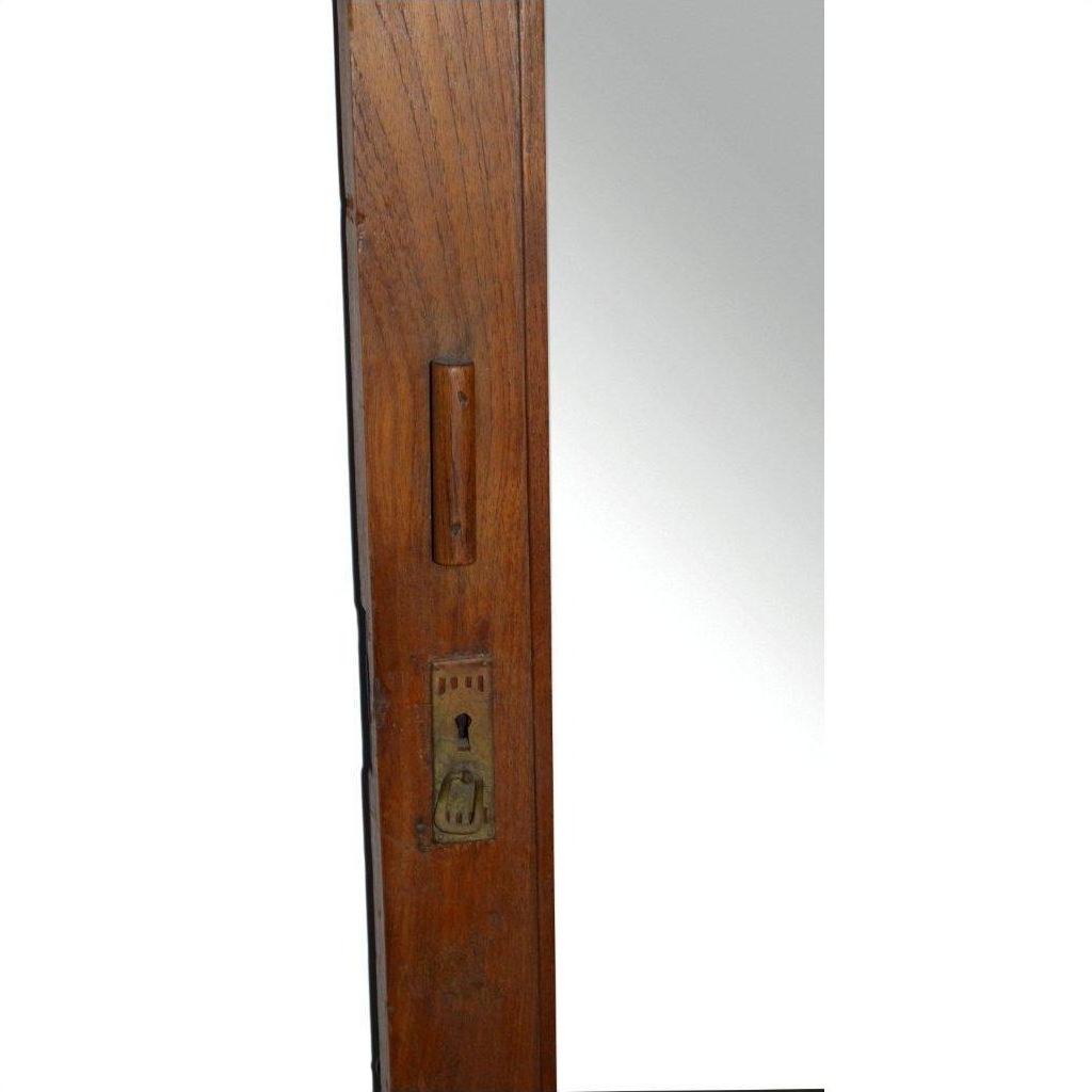 Close-up of silver metal mortise lock and rectangular cutout on antique mirror edge against white background.