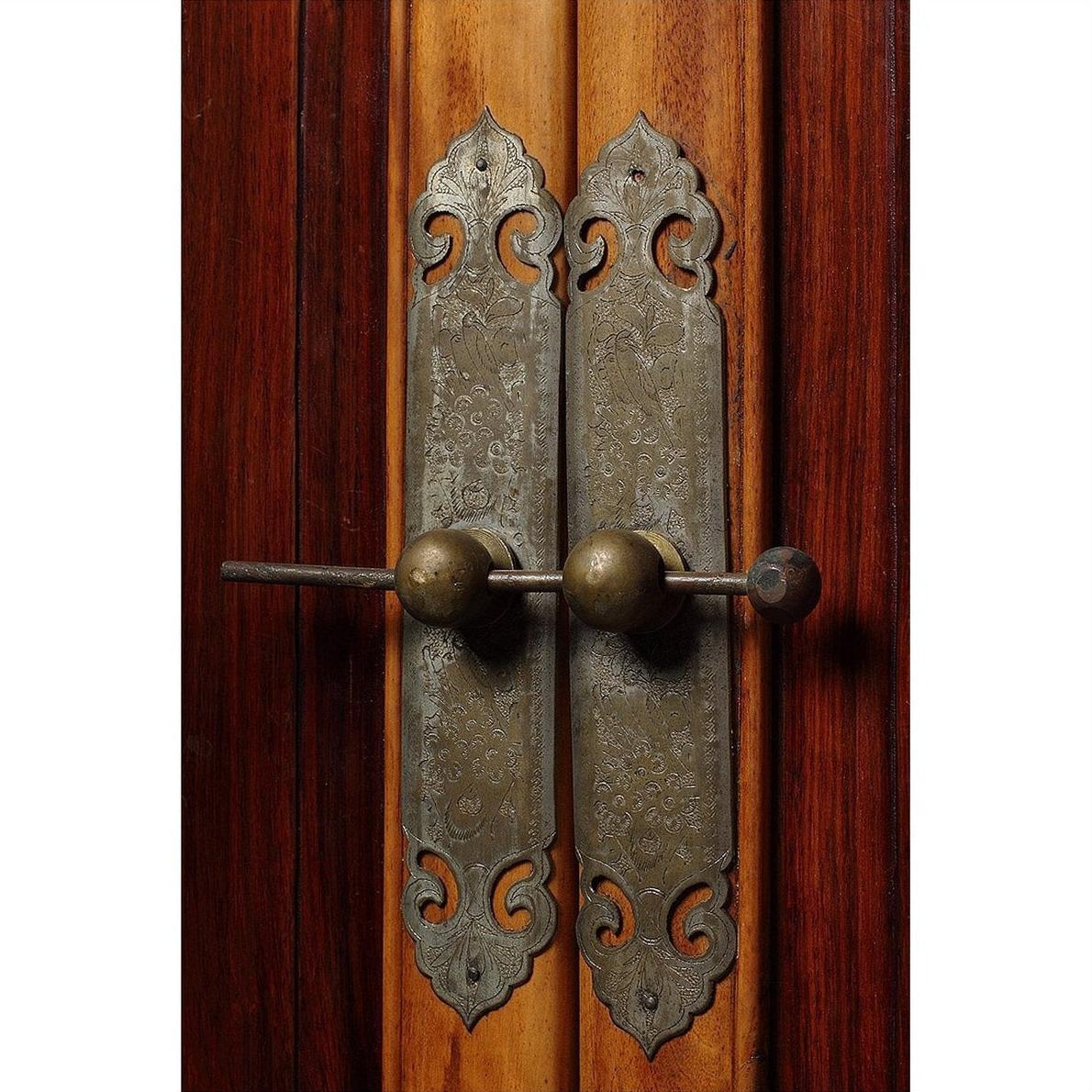 Close-up of ornate vintage metal door handles on 19th-century Chinese Ningbo elm and cypress wood cabinet.