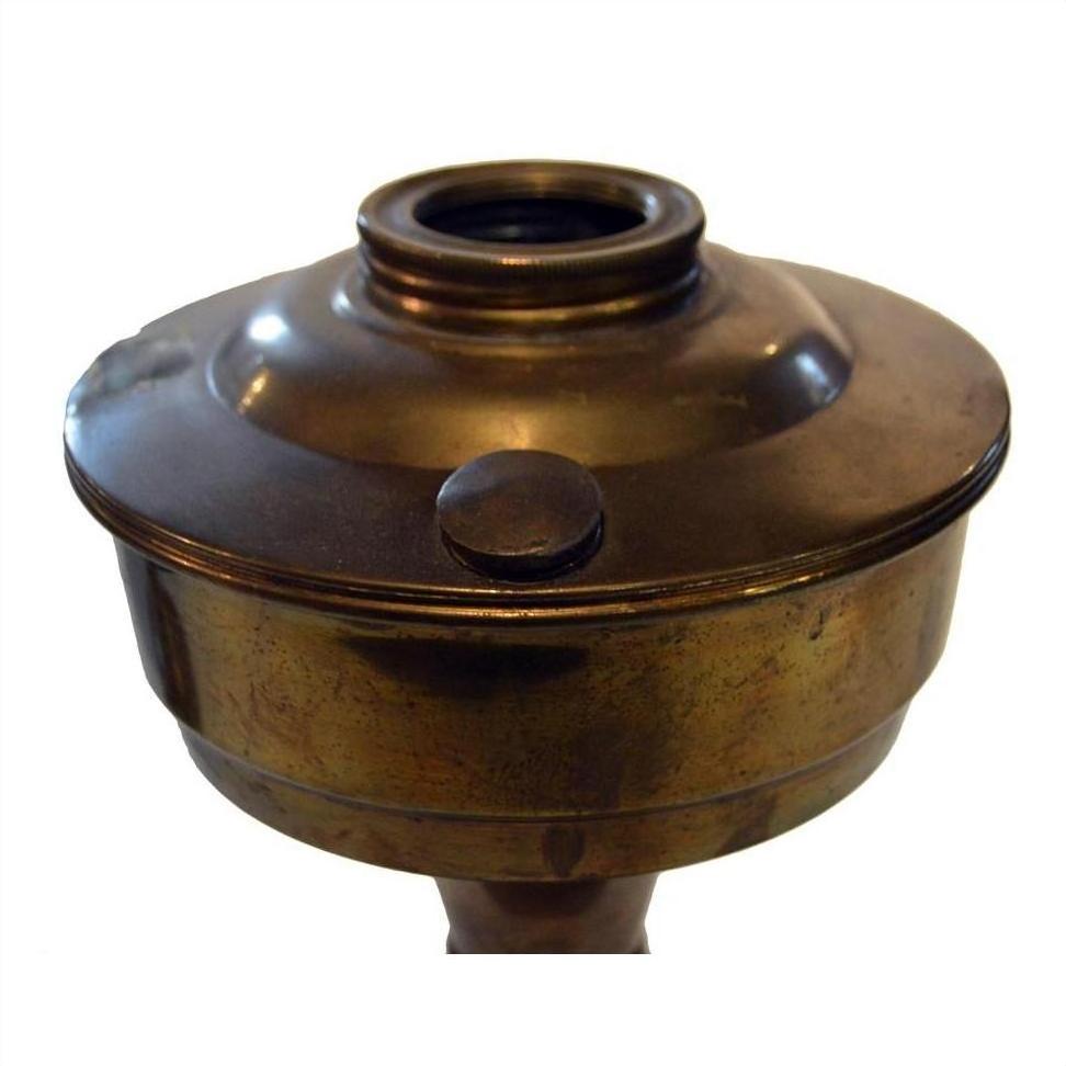 Brass oil lamp with round fuel chamber and threaded top, antique style, close-up view.