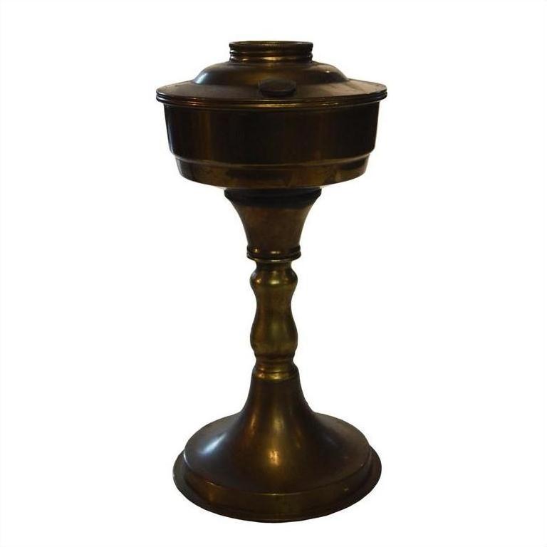 Brass oil lamp with antiqued finish, wide base, slender stem, and lidded container, classic decor style.