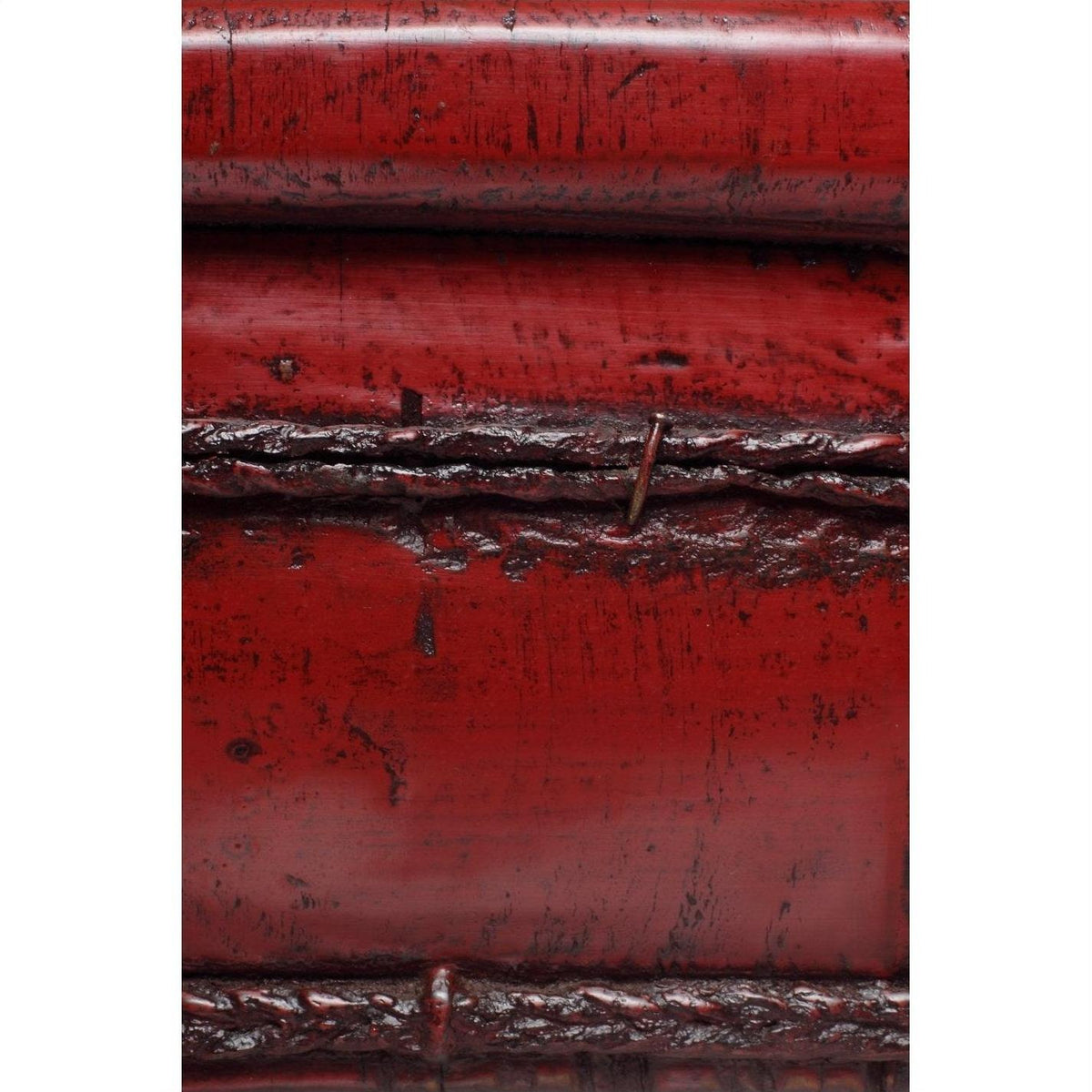 Close-up of antique red wooden basin with weathered finish, visible seams, and surface scratches.