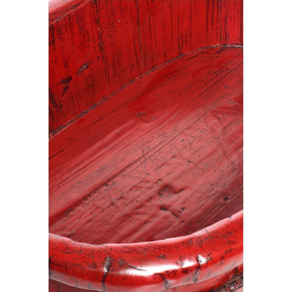 Close-up of distressed red lacquered wooden basin showing textured scratches and rounded edge.