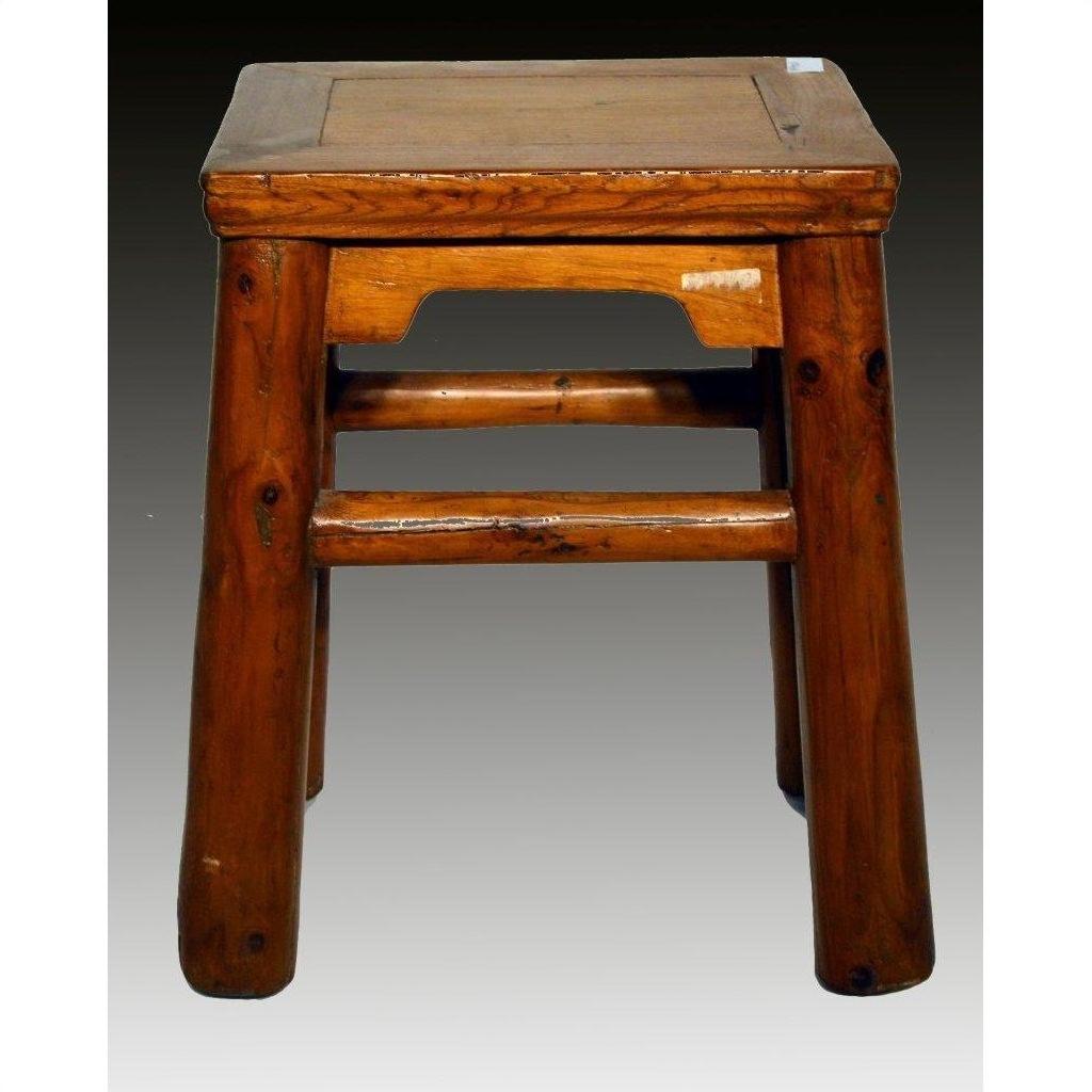 Close-up of rustic elm wood antique stool with four legs and square seat, set against a gradient dark background.