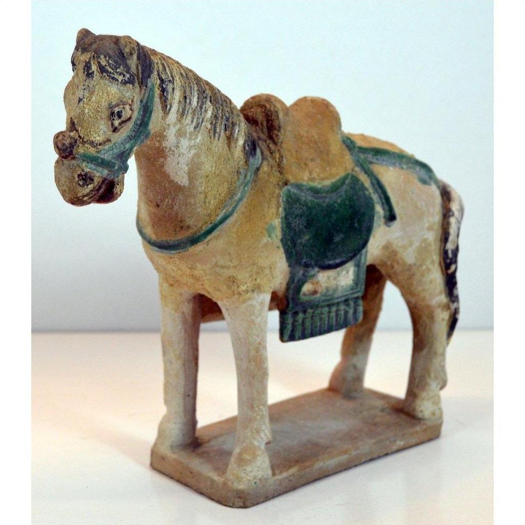 Green glazed terracotta Ming Dynasty horse with saddle on rectangular base, close-up.
