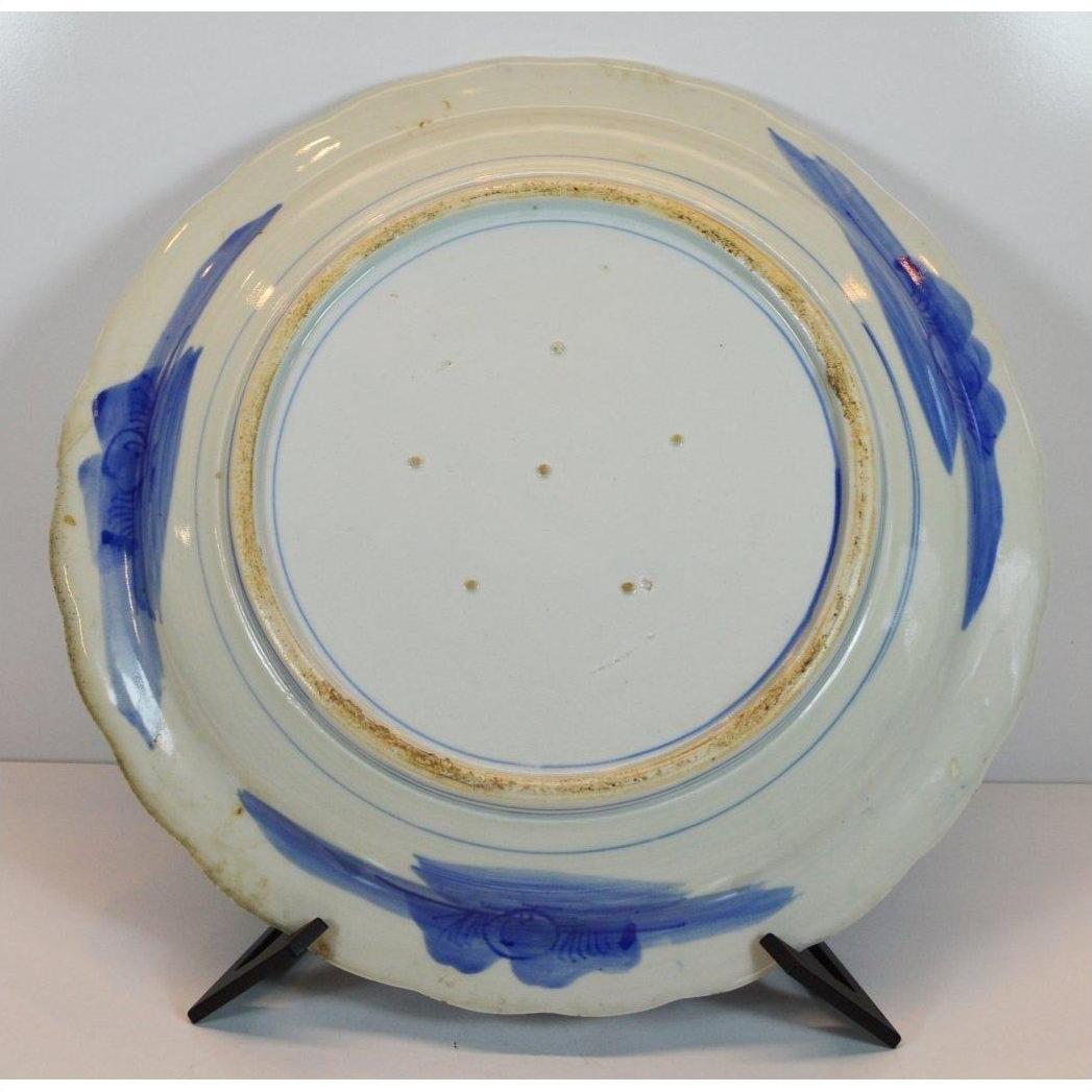 Close-up of the white porcelain ARITA MEIJI plate back with blue brushstrokes on a black display stand.
