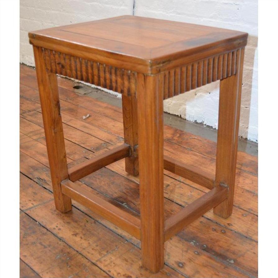 Brown Art Deco stool with wooden legs on a wood floor, positioned near a white brick wall in Shanghai.