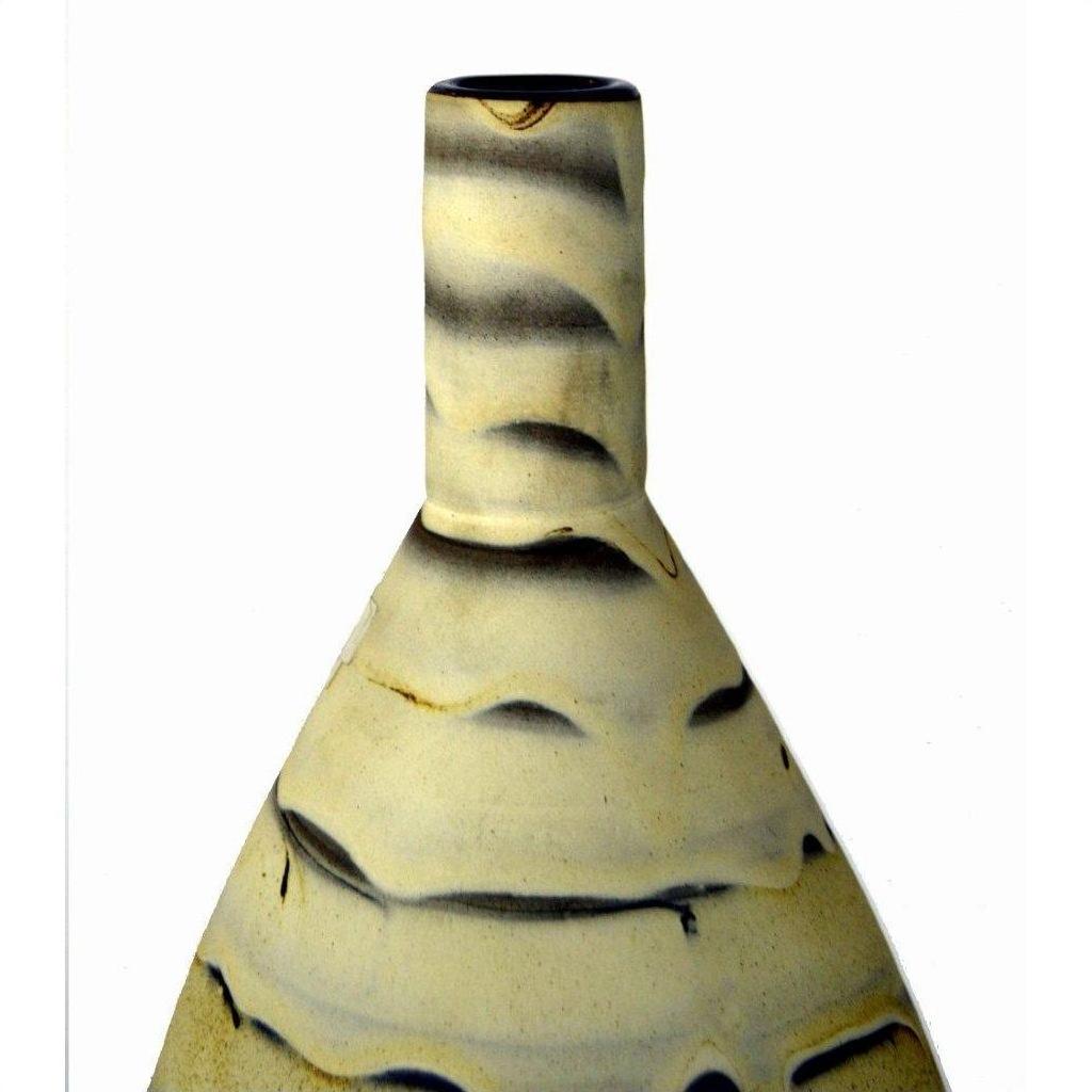 Close-up of large white ceramic vase with narrow neck and wavy earth tone marbling pattern.