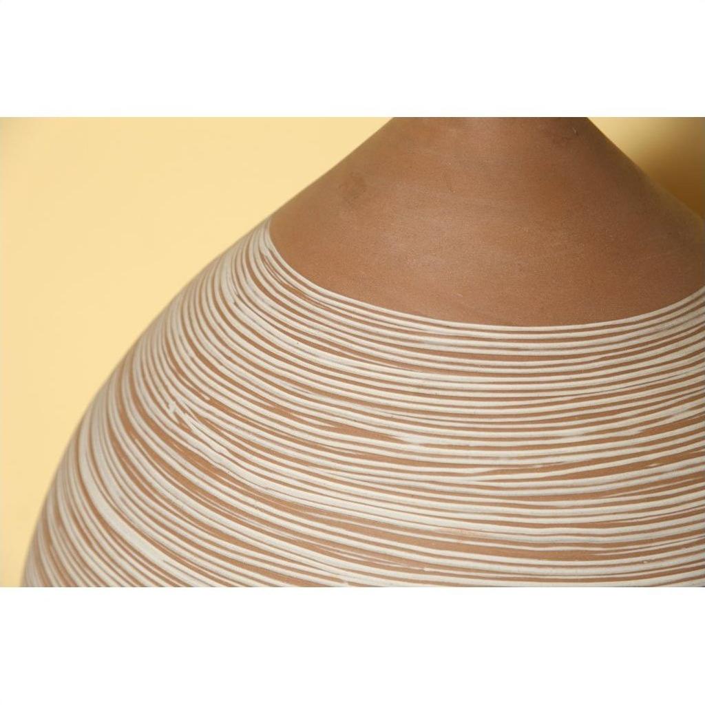 Close-up of large white-striped ceramic vase against a pale yellow background.