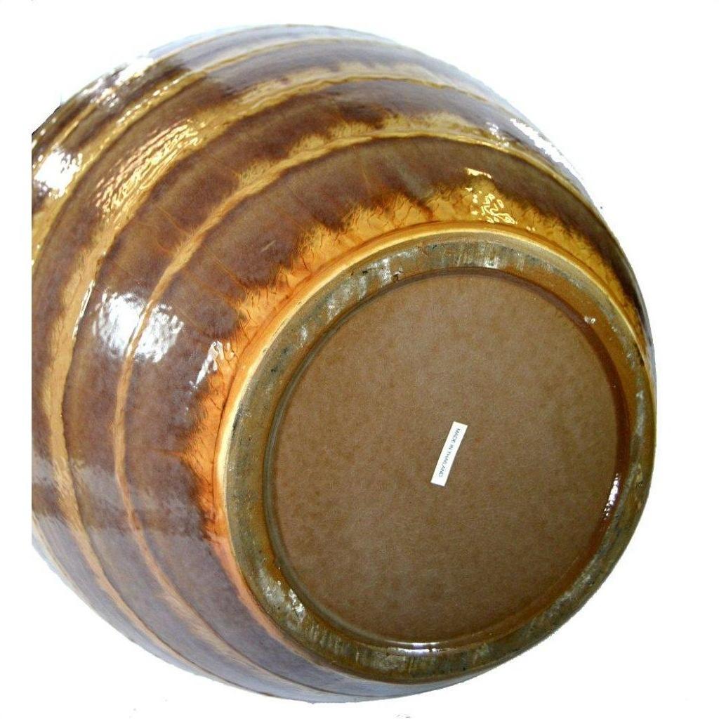 Close-up of a large ceramic vase with earth tones glaze, label visible on the bottom.