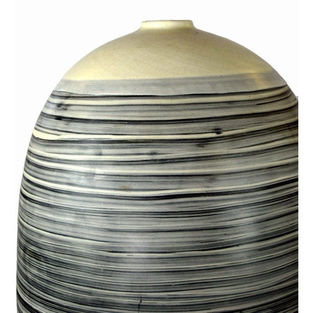 White ceramic vase with rounded top and black-gray stripes, close-up against a plain background.