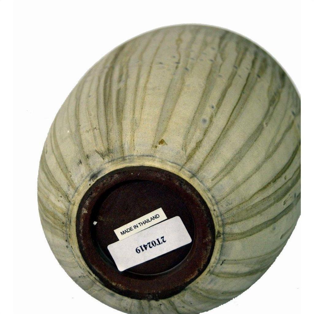 White ceramic vase upside down, barcode sticker and Made in Thailand label visible on base, close-up.