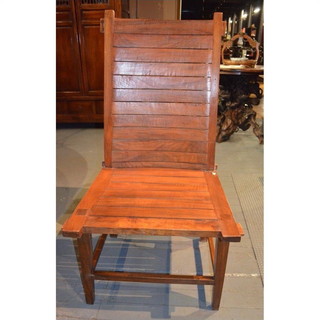 Brown teak armless chair with horizontal slats, Arts &amp; Crafts style, on a gray indoor floor.